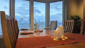 a dining room table with a view of the ocean at Villa Lyngenfjord in Olderdalen