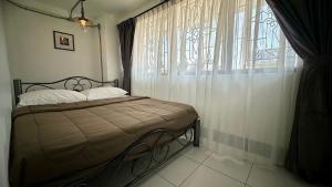 a bedroom with a bed and a large window at Backpack Hostel in Chiang Rai