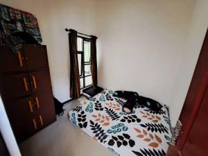 1 dormitorio con 1 cama, vestidor y ventana en Villa Murah di Malang, en Malang