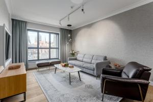 a living room with a couch and a table at Apartamenty Chmielna 10 - kompleks Deo - Old Town in Gdańsk