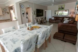 a kitchen and living room with a table and chairs at Surf n Sea Beachfront Holiday Home in Jeffreys Bay