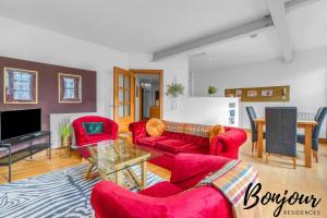 ein Wohnzimmer mit roten Sofas und einem TV in der Unterkunft Sentier Suite - Chic 1BR-1BA,Heart of Edinburgh, Old Town by Bonjour Residences Edinburgh in Edinburgh