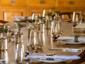 a long wooden table with glasses and plates on it at Mymering Wine & Guest Estate in Ladismith