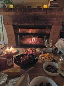 a table with a fireplace filled with food and candles at Mökki merenrannalla Vuosaaressa in Helsinki