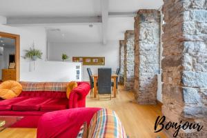 ein Wohnzimmer mit einem roten Sofa und einem Tisch in der Unterkunft Sentier Suite - Chic 1BR-1BA,Heart of Edinburgh, Old Town by Bonjour Residences Edinburgh in Edinburgh