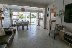 a living room with a table and a dining room at Surf n Sea Beachfront Holiday Home in Jeffreys Bay