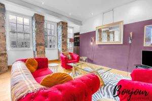 ein Wohnzimmer mit roten Sofas und einem TV in der Unterkunft Sentier Suite - Chic 1BR-1BA,Heart of Edinburgh, Old Town by Bonjour Residences Edinburgh in Edinburgh