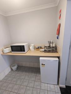 a kitchen with a counter with a microwave and a refrigerator at Toodyay Hotel in Toodyay