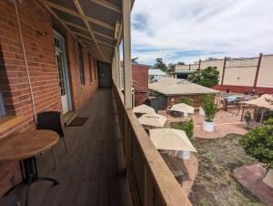 a balcony with tables and chairs on a building at Toodyay Hotel in Toodyay
