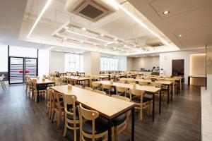 uma grande sala de jantar com mesas e cadeiras em Shin Shin Hotel Jeju Ocean em Seogwipo