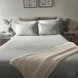 een bed met witte lakens en kussens in een slaapkamer bij Toodyay Hotel in Toodyay