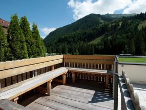 dwie drewniane ławki na tarasie z widokiem na góry w obiekcie Apartment in Saalbach-Hinterglemm with sauna w Saalbach Hinterglemm
