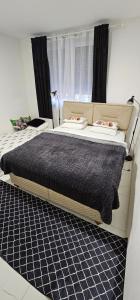 a bedroom with a large bed with a black blanket at MURIC Apartman 2 in Ljubljana