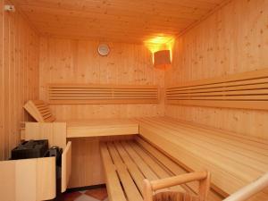 un sauna avec des murs lambrissés et des bancs dans l'établissement Apartment in Saalbach-Hinterglemm with sauna, à Saalbach-Hinterglemm