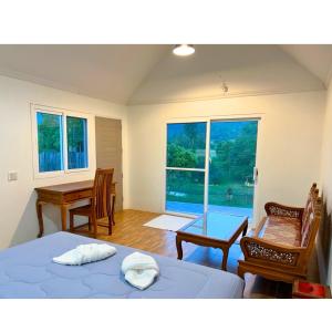 a bedroom with two beds and a desk and a window at Quality Time Farmstay: River House in Ban Pa Lau