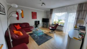 un soggiorno con divano rosso e tavolo di Seeberger Ferienwohnung a Höxter
