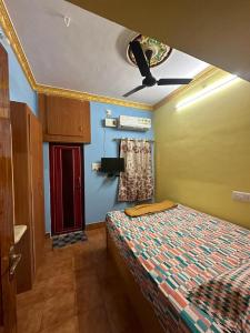 a bedroom with a bed and a ceiling fan at VM Residency in Yelagiri