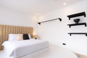 a bedroom with a white bed and black shelves at Casa Art Ubud in Ubud