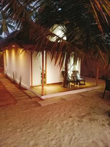 una casa en la playa con una palmera en Havana Beach House en Alleppey