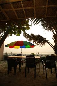 una mesa con una sombrilla colorida en la playa en Havana Beach House, en Alleppey