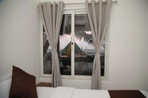 sypialnia z łóżkiem i oknem z zasłonami w obiekcie Havana Beach House w mieście Alappuzha