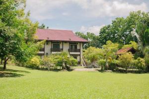 una casa con un césped verde delante de ella en Singgahsana Villa en Kuah