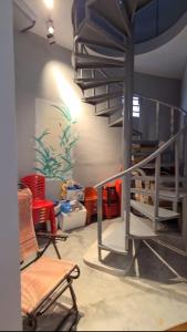 salon ze spiralnymi schodami i krzesłami w obiekcie Hakka Holiday Home w mieście Lengging