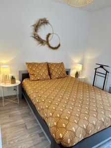 a bedroom with a bed and two tables with lamps at Le Tournassin-Balcon-Stationnement gratuit in Bourg-en-Bresse