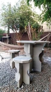 uma mesa e dois bancos sentados numa terra de cascalho em Casa linda e aconchegante para hóspedes.(Studio) em Joinville