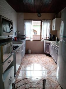 a kitchen with washers and dryers on a tile floor at Casa linda e aconchegante para hóspedes.(Studio) in Joinville