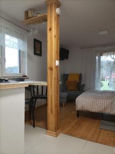 a kitchen and living room with a table and a bed at Pod Jabłonią in Szczawnica