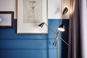 a floor lamp in a room with a blue wall at The Hoxton, Amsterdam in Amsterdam +27 photos
