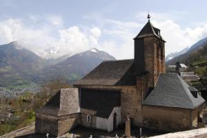 uma velha igreja com montanhas ao fundo em Chalet Mina em Sazos