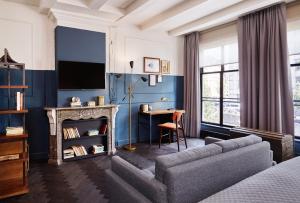 a living room with a couch and a desk at The Hoxton, Amsterdam in Amsterdam
