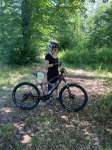 a woman standing next to a bike in the woods at Chalet Martuška - Drevenica so saunou - Celá dolina len pre vás in Levoča