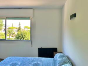 a bedroom with a bed and a window at Cozy studio in calm in Mandelieu-la-Napoule