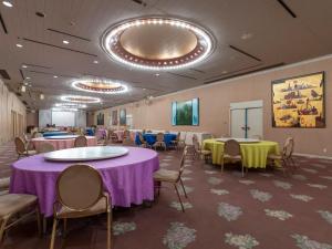 uma sala de banquetes com mesas e cadeiras e mesas roxas e amarelas em Tabist Hotel Liberty Plaza em Sakai