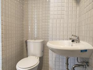 uma casa de banho branca com um WC e um lavatório em Alhesa Apartment em Sunggal