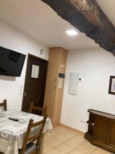 uma sala de jantar com uma mesa e uma televisão na parede em Casa San Antonio em Albarracín