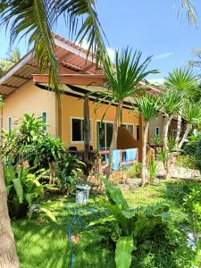 une maison avec des palmiers dans la cour dans l'établissement Sea Shell Beach Resort, à Ko Lanta