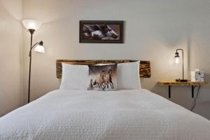 a bedroom with a bed with a white bedspread at Lake Village Lodge in Coeur d'Alene