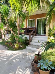 a house with a porch with palm trees and plants at Sea Shell Beach Resort in Ko Lanta