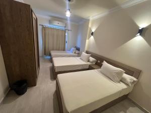 a small room with two beds and a window at MARINA SKY in Hurghada