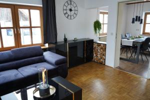 a living room with a blue couch and a kitchen at Ferienwohnung "Seaside Deluxe" in Lindenberg im Allgäu