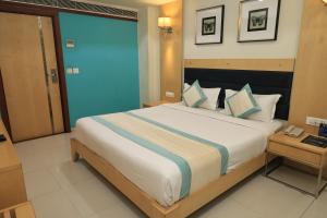 a bedroom with a large bed in a room at SN Blu Hotel in Ahmedabad