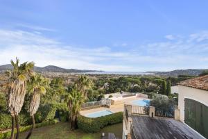 een luchtzicht op een villa met een zwembad en palmbomen bij Les Terrasses de Cogolin in Cogolin