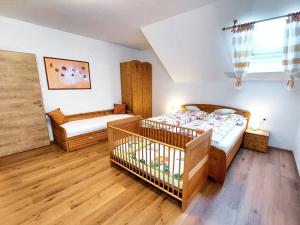 a bedroom with two beds and a crib in it at Landhaus Schaidreith in Ferschnitz
