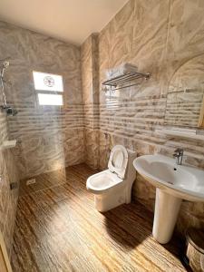 ein Bad mit einem WC und einem Waschbecken in der Unterkunft Remal Ibri hotel in Ibri