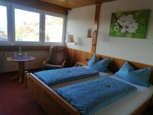 a hotel room with two beds and a table at Hotel-Restaurant Rebstock in Vogtsburg