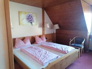 a bedroom with two beds with pink pillows at Hotel-Restaurant Rebstock in Vogtsburg